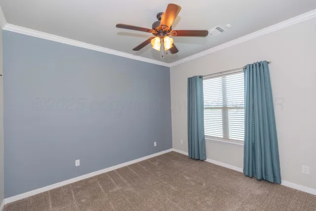 a view of an empty room and a chandelier fan