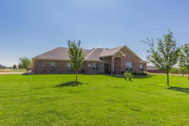 a house with a big yard and large trees