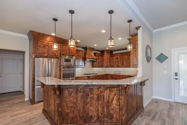a kitchen with stainless steel appliances kitchen island a chandelier
