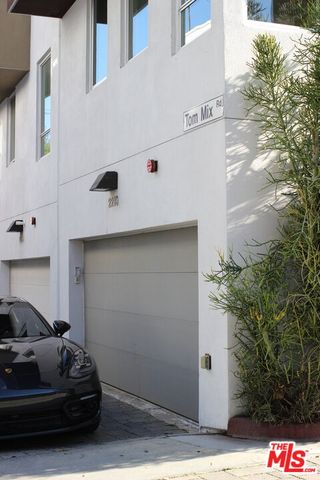 a front view of a house with plants
