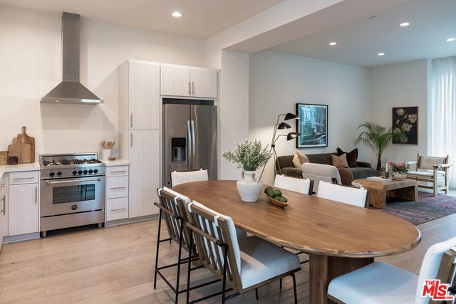 a living room with stainless steel appliances furniture a dining table and chairs