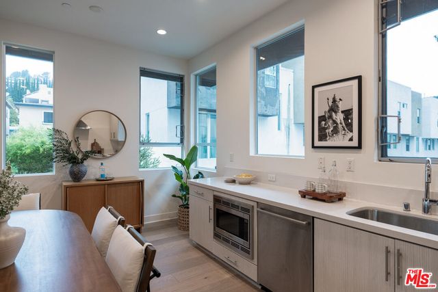 a living room with furniture a potted plant and kitchen countertops