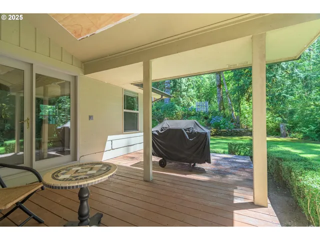 a view of a patio with table and chairs potted plants with wooden floor and fence