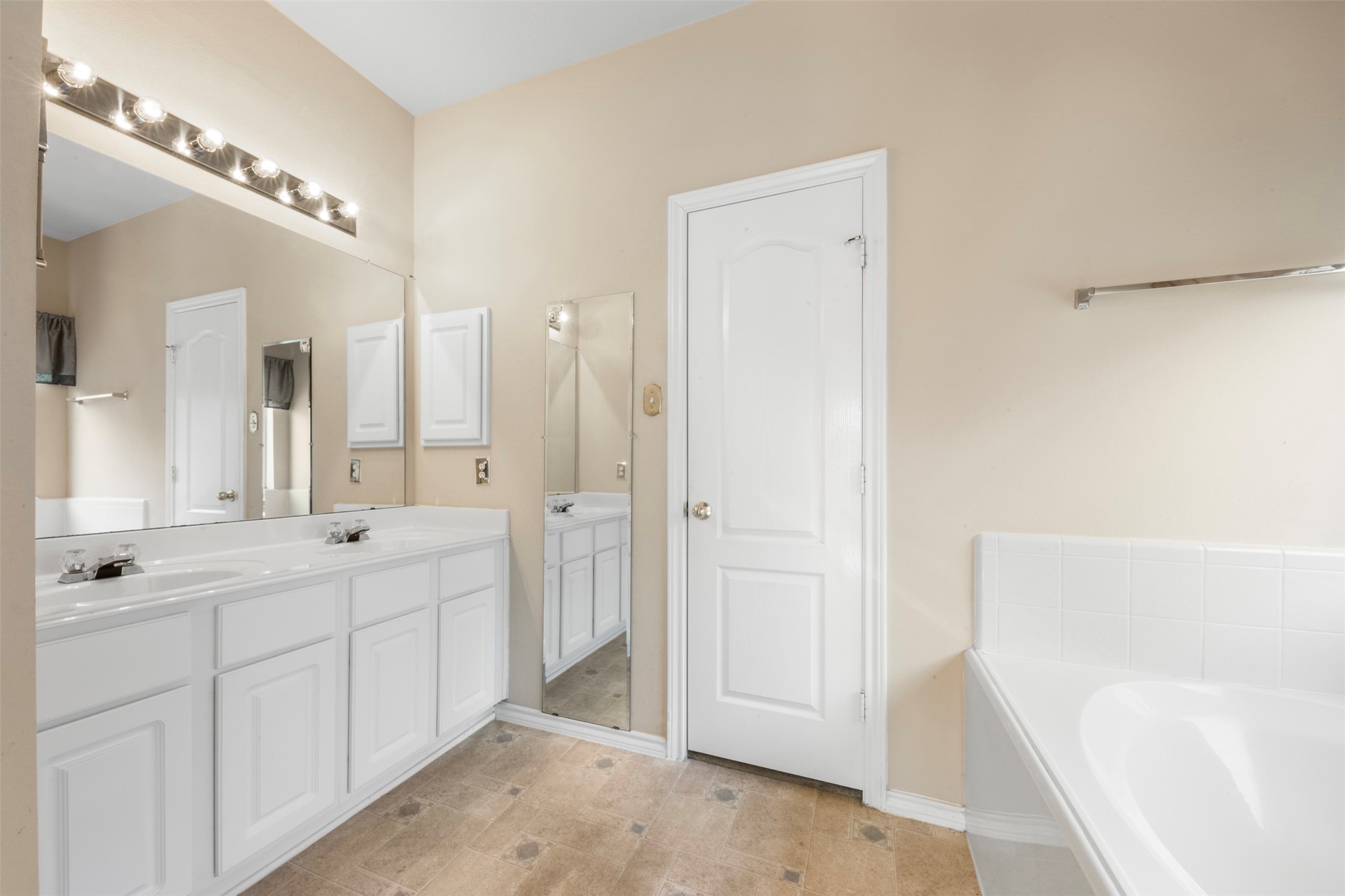 1839 Manor Drive Baytown, TX 77521 - Photo 13 of 26 a spacious bathroom with a double vanity sink a mirror and a bathtub