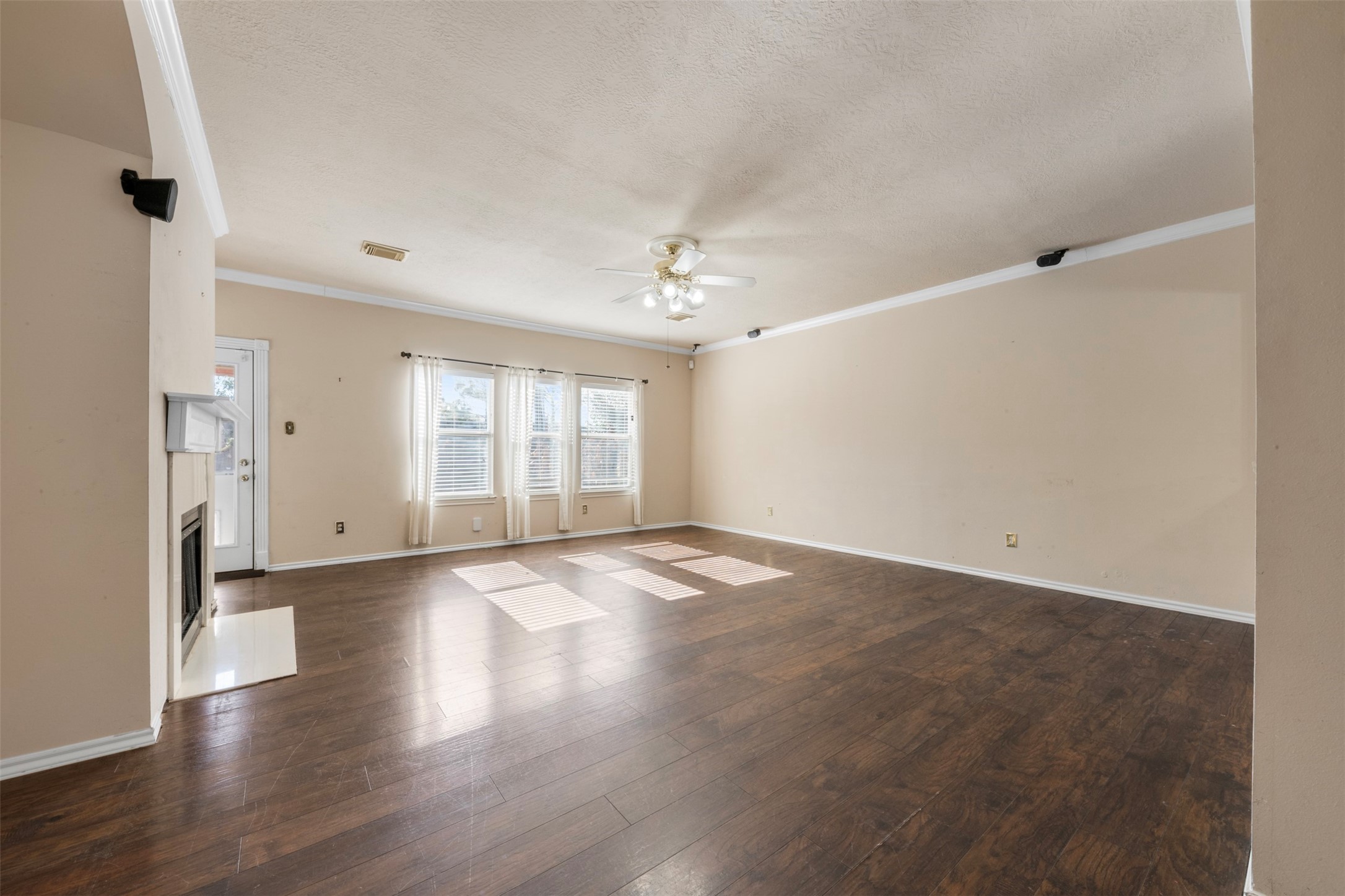 1839 Manor Drive Baytown, TX 77521 - Photo 4 of 26 an empty room with wooden floor and windows