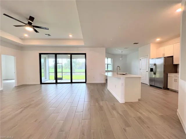 a view of large kitchen with a sink and wooden floor