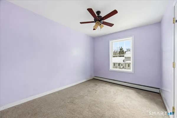 an empty room with window and ceiling fan