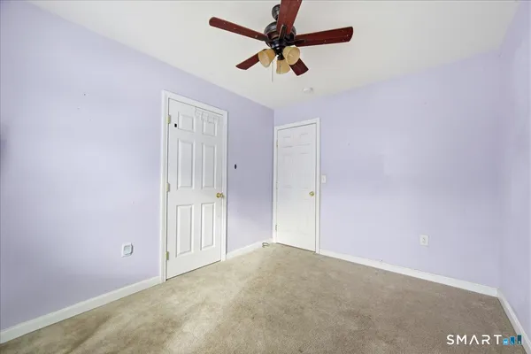 an empty room with a ceiling fan and a window