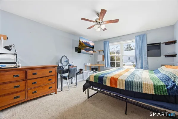 a bedroom with a bed a dresser and flat screen tv
