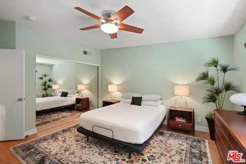 a spacious bedroom with a bed a mirror and lamp