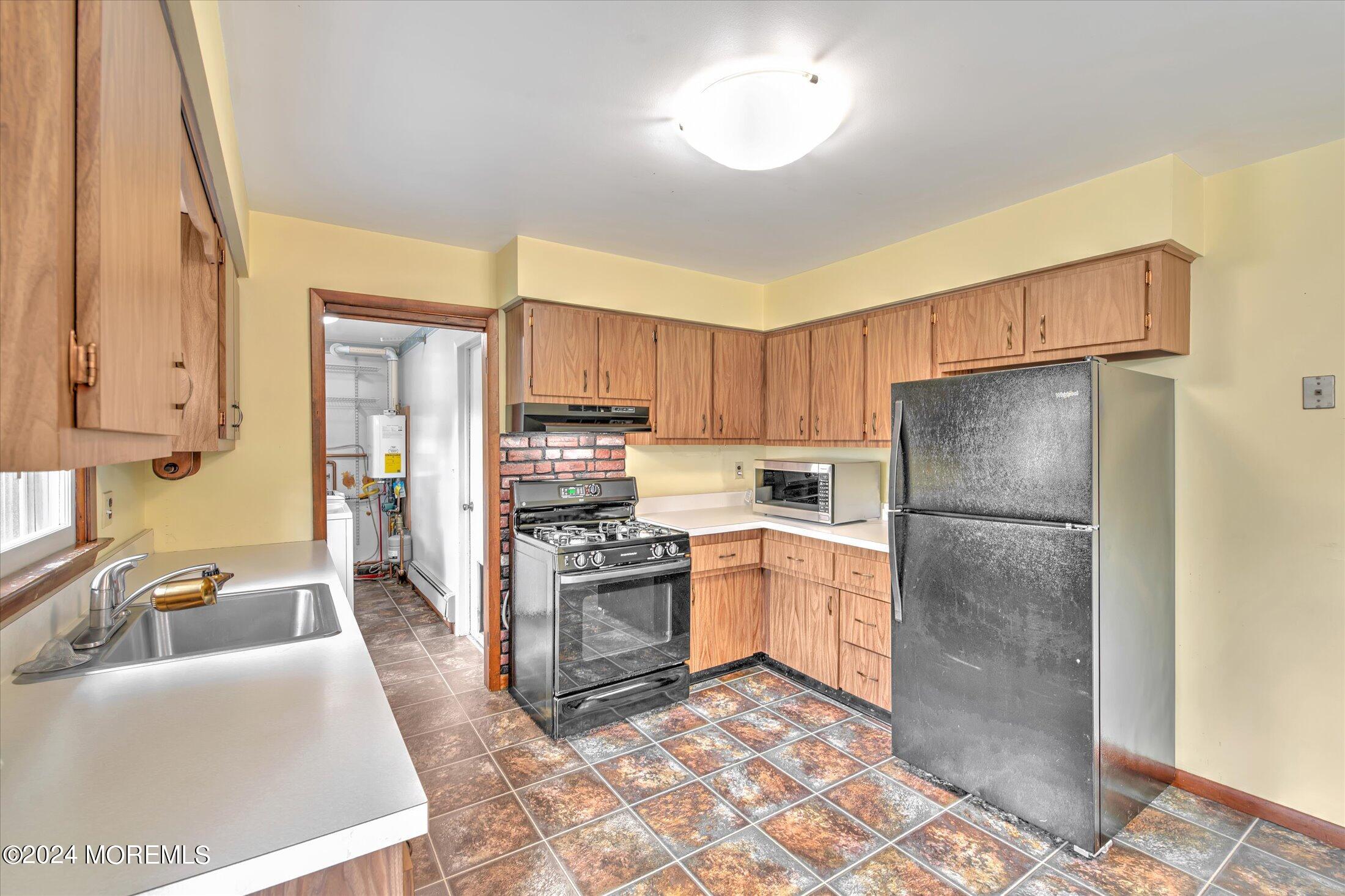2209 Glen Oak Drive Forked River, NJ 08731 - Photo 13 of 44 a kitchen with stainless steel appliances granite countertop a refrigerator a stove a sink a dining table and chairs with wooden floor