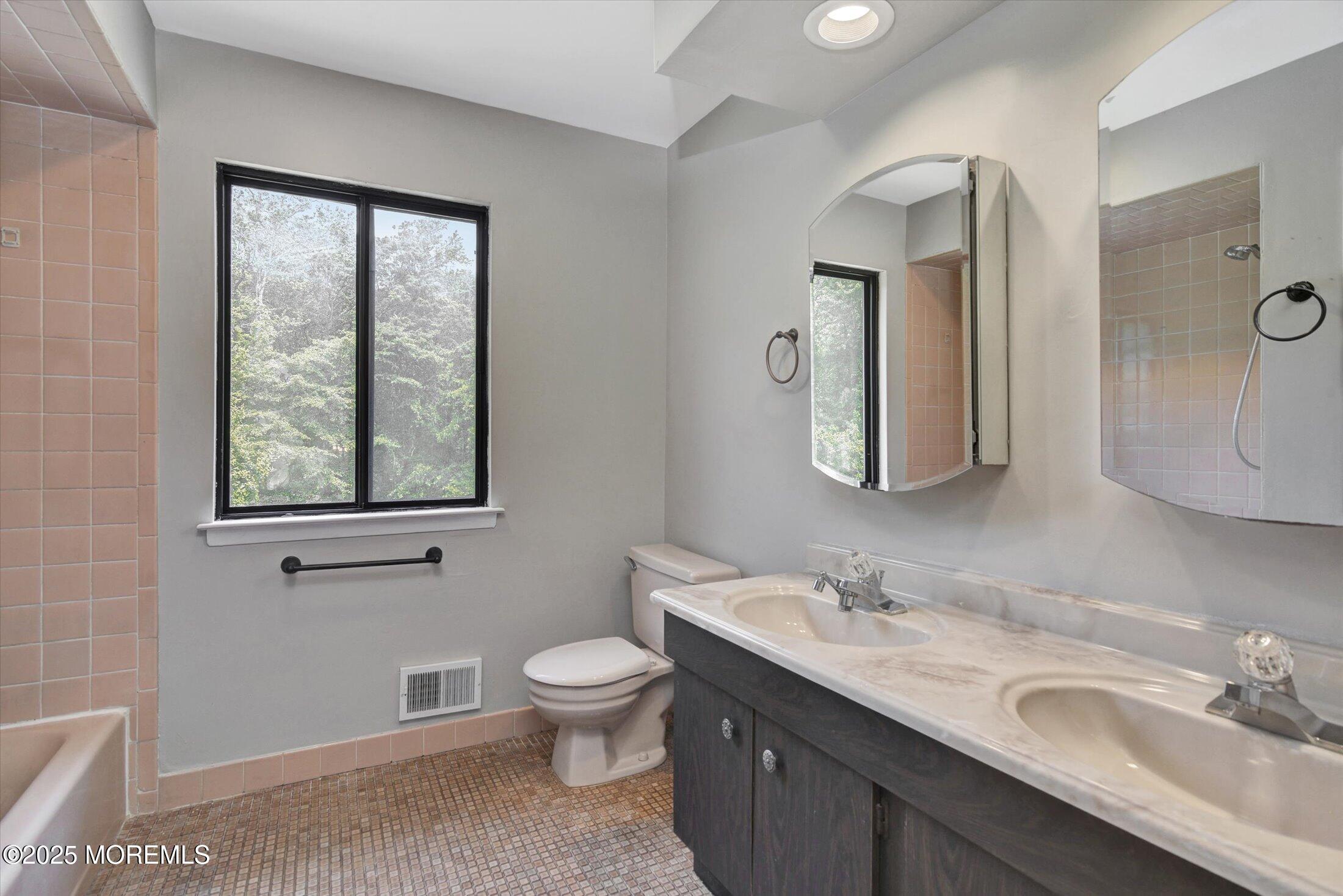 19 Northwoods Road Asbury Park, NJ 07712 - Photo 29 of 79 a bathroom with a granite countertop toilet a sink and mirror