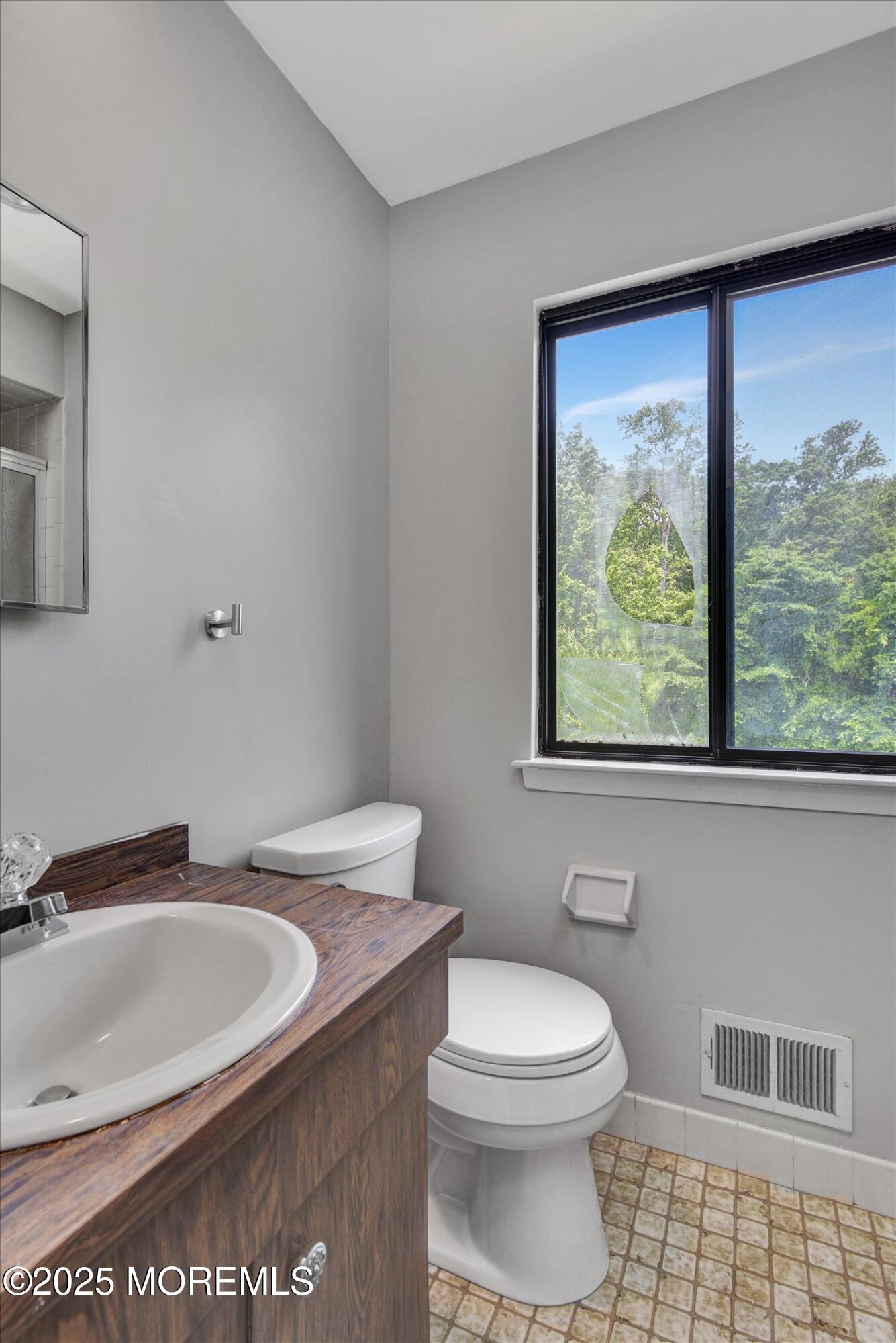19 Northwoods Road Asbury Park, NJ 07712 - Photo 32 of 79 a bathroom with a toilet a sink and a mirror