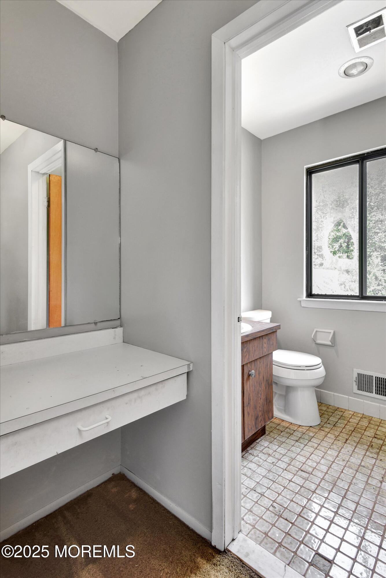 19 Northwoods Road Asbury Park, NJ 07712 - Photo 33 of 79 a bathroom with a toilet a sink and mirror