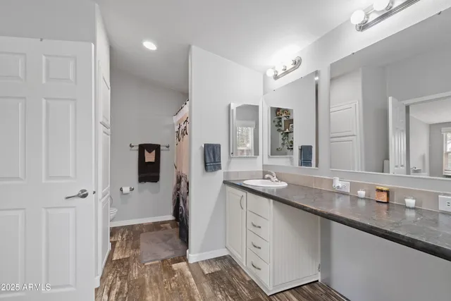 a spacious bathroom with a granite countertop sink a mirror and a