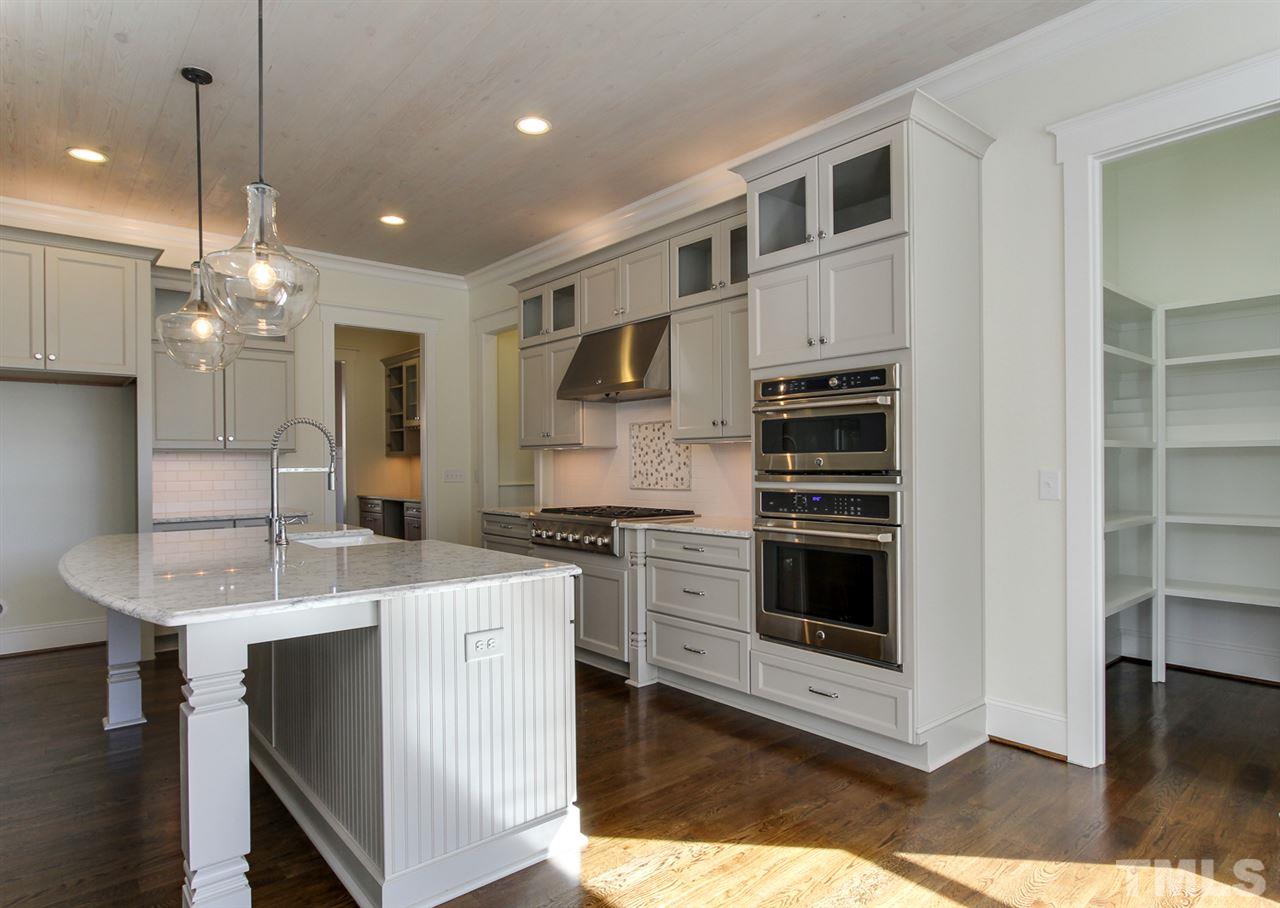 701 Shelley Road Raleigh, NC 27609 - Photo 11 of 25 a kitchen with stainless steel appliances kitchen island a stove and a sink
