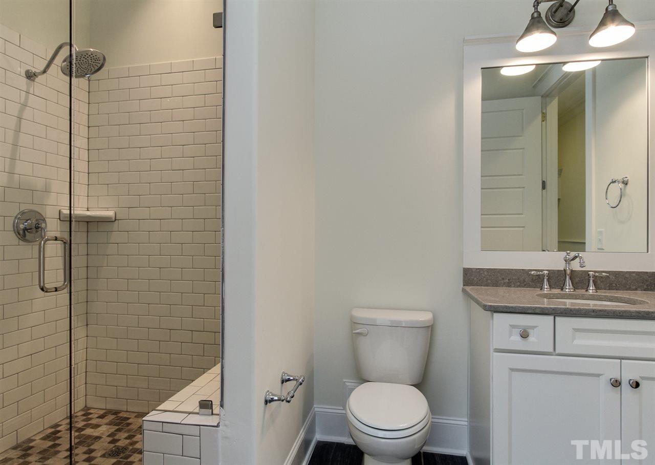 701 Shelley Road Raleigh, NC 27609 - Photo 15 of 25 a bathroom with a granite countertop toilet a sink and a mirror