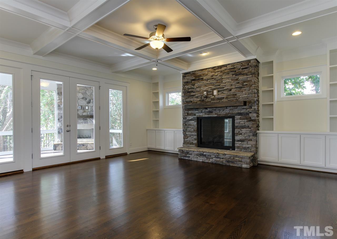 701 Shelley Road Raleigh, NC 27609 - Photo 6 of 25 a view of an empty room with wooden floor fireplace and a window