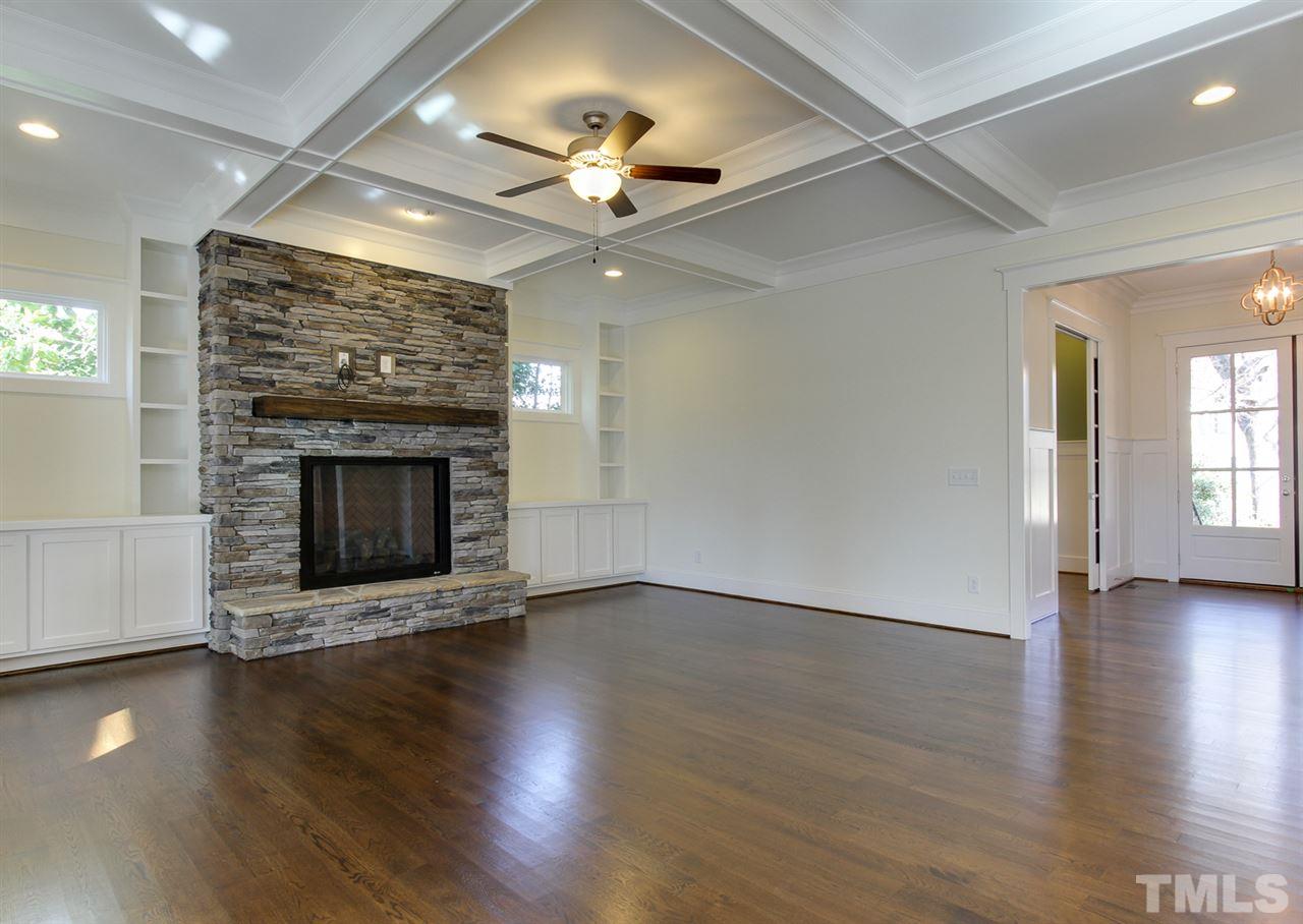 701 Shelley Road Raleigh, NC 27609 - Photo 7 of 25 an empty room with wooden floor fireplace and windows