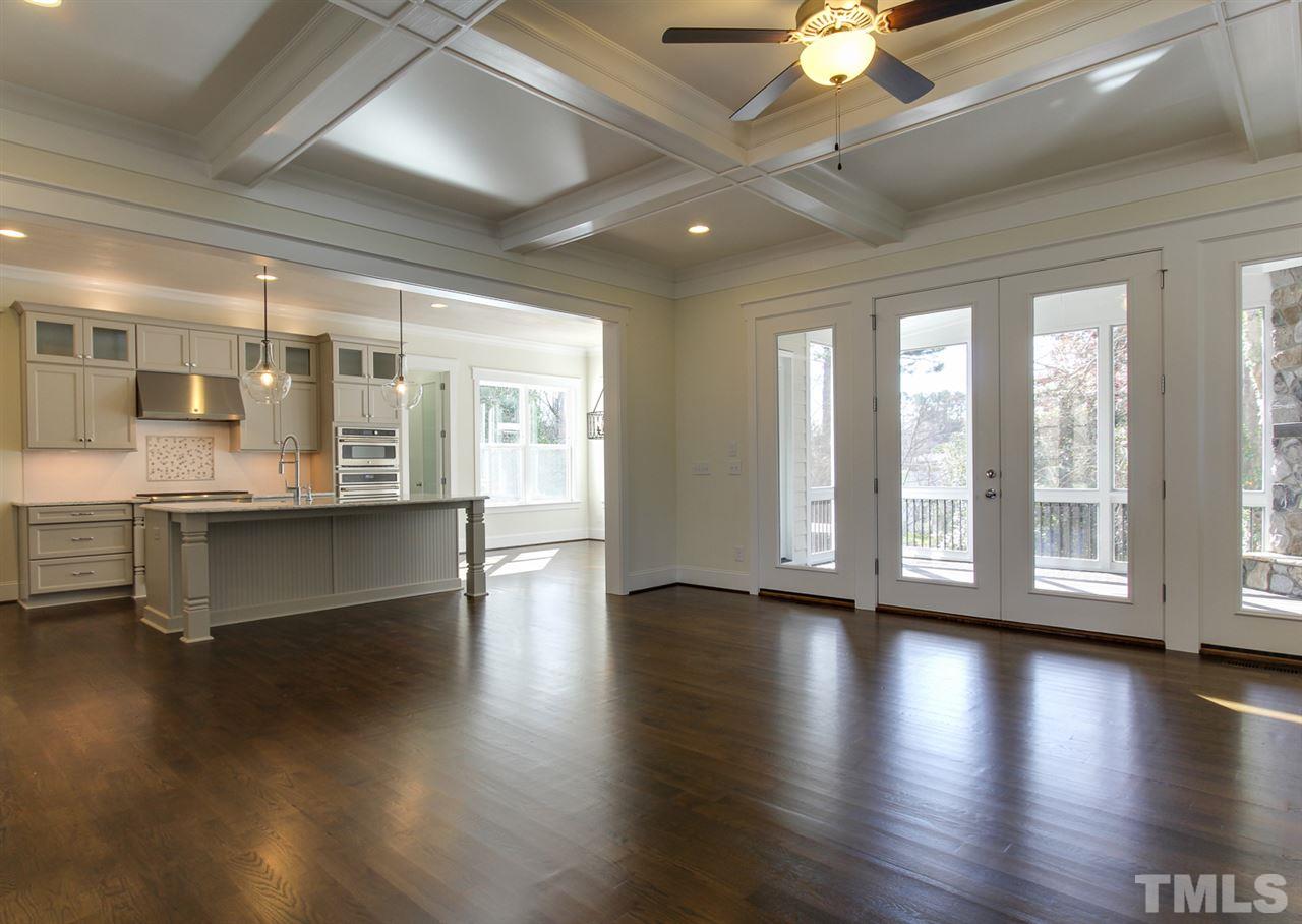 701 Shelley Road Raleigh, NC 27609 - Photo 8 of 25 a view of an empty room with wooden floor and a kitchen