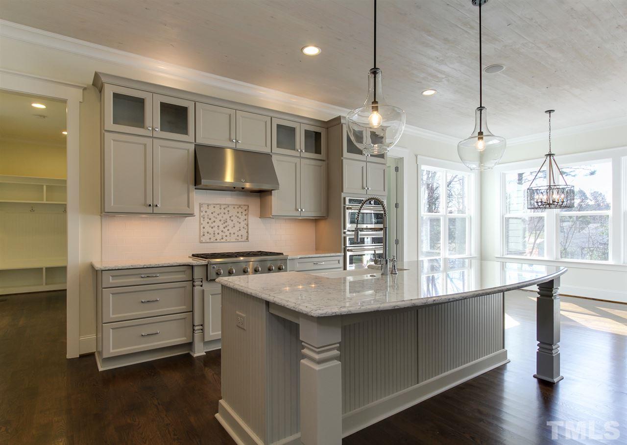 701 Shelley Road Raleigh, NC 27609 - Photo 10 of 25 a kitchen with kitchen island a sink stainless steel appliances and cabinets