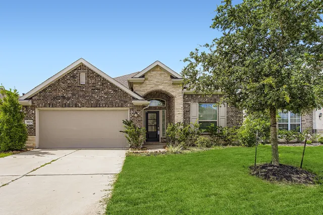 a front view of a house with a garden and trees
