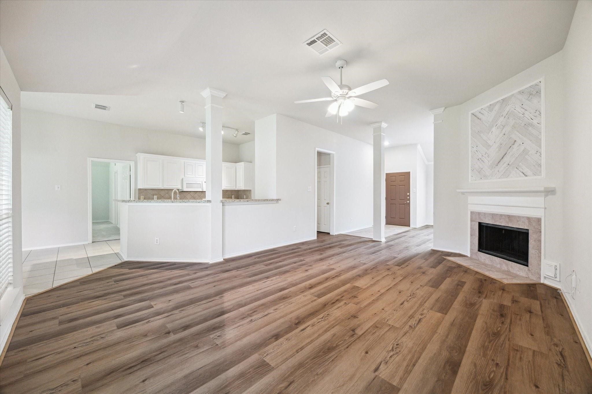 8211 Broken Timber Way Houston, TX 77095 - Photo 6 of 15 a view of a livingroom with a fireplace a ceiling fan and wooden floor