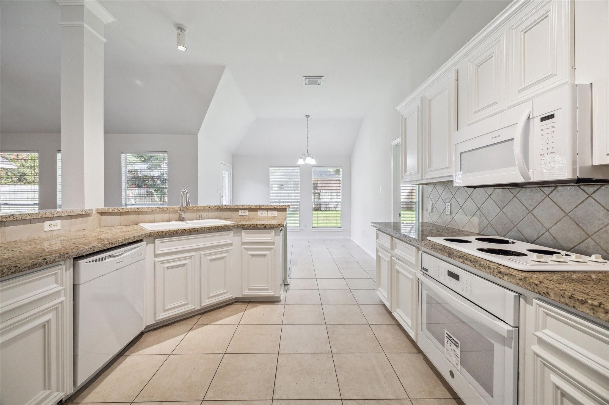8211 Broken Timber Way Houston, TX 77095 - Photo 9 of 15 a kitchen with granite countertop white cabinets and appliances