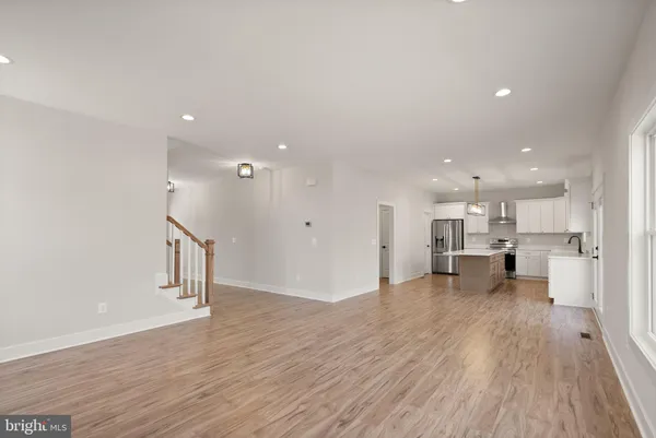 a large kitchen with kitchen island a large counter space a sink appliances and cabinets