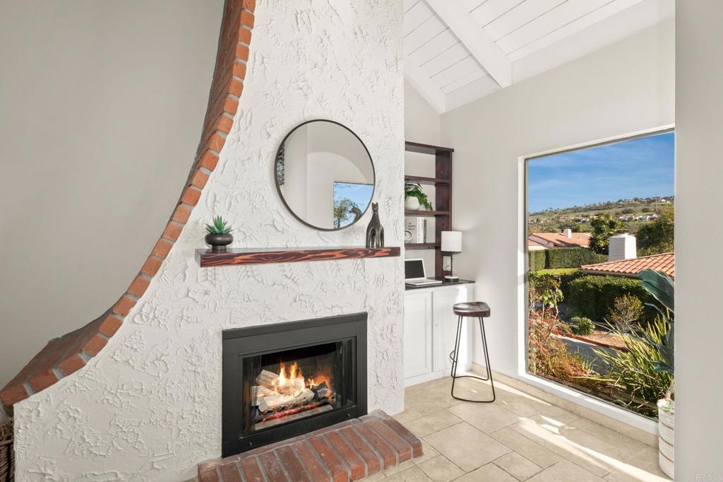 1939 Alga Road, Unit A Carlsbad, CA 92009 - Photo 25 of 32 a living room with a fireplace a clock and a window