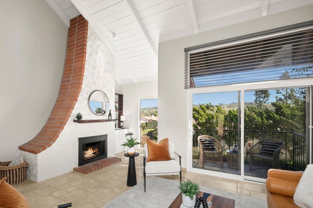 1939 Alga Road, Unit A Carlsbad, CA 92009 - Photo 26 of 32 a living room with furniture a fireplace and a floor to ceiling window