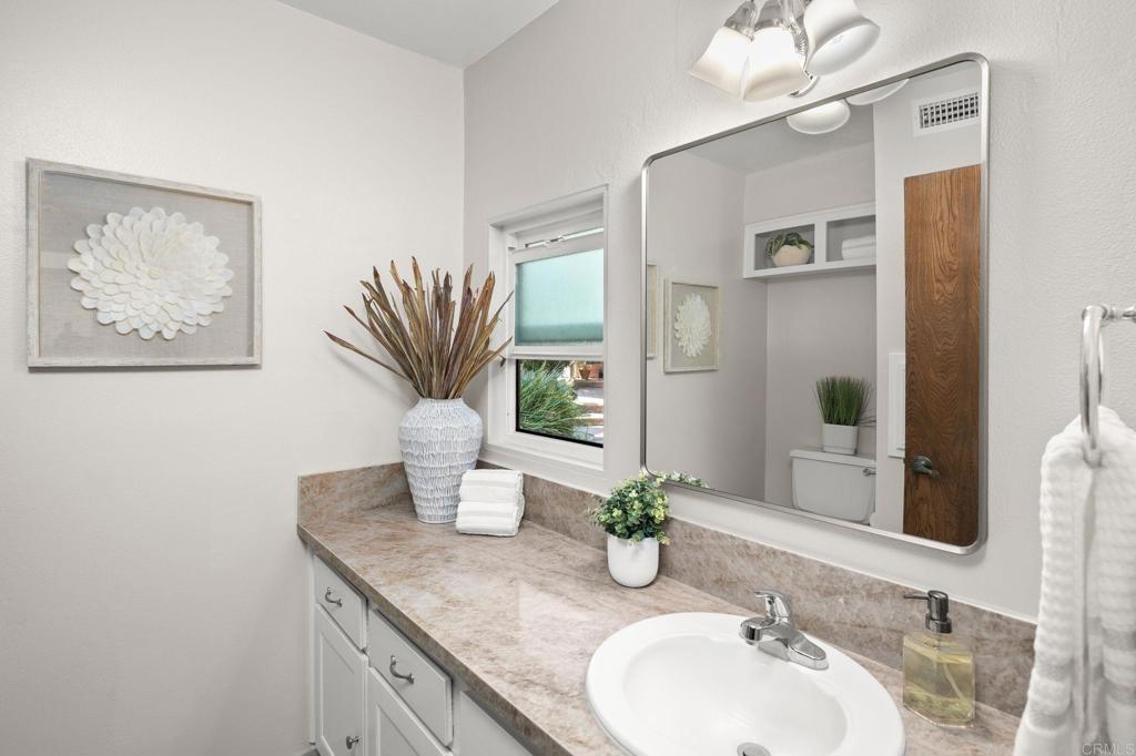 1939 Alga Road, Unit A Carlsbad, CA 92009 - Photo 9 of 32 a bathroom with a granite countertop sink a mirror and a shower