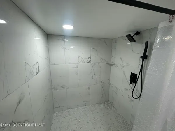 a bathroom with a granite countertop sink a mirror and shower