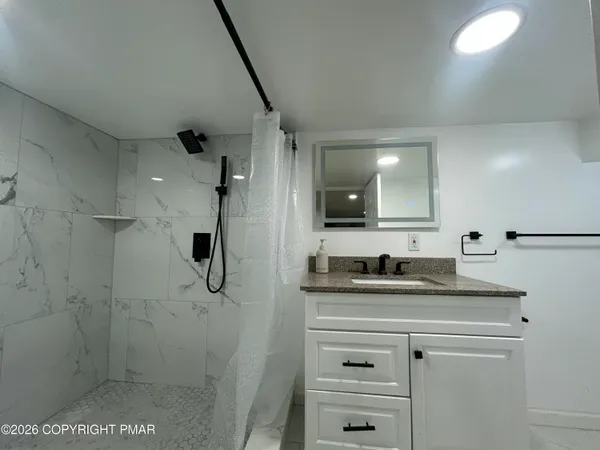 a bathroom with a granite countertop sink a toilet and mirror