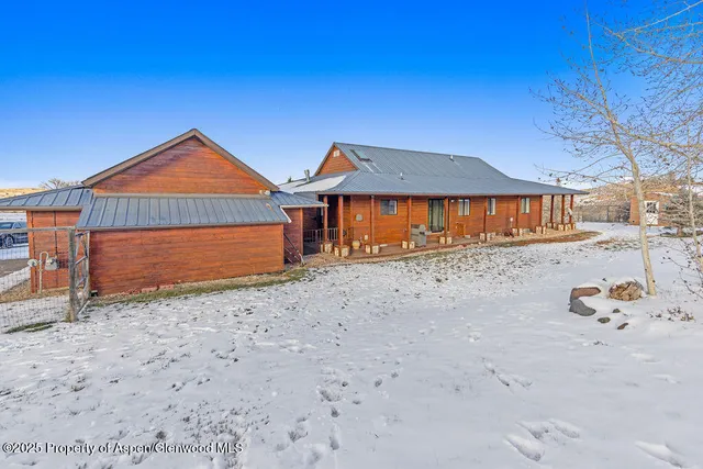 a kitchen with stainless steel appliances kitchen island granite countertop a table chairs in it and wooden floors
