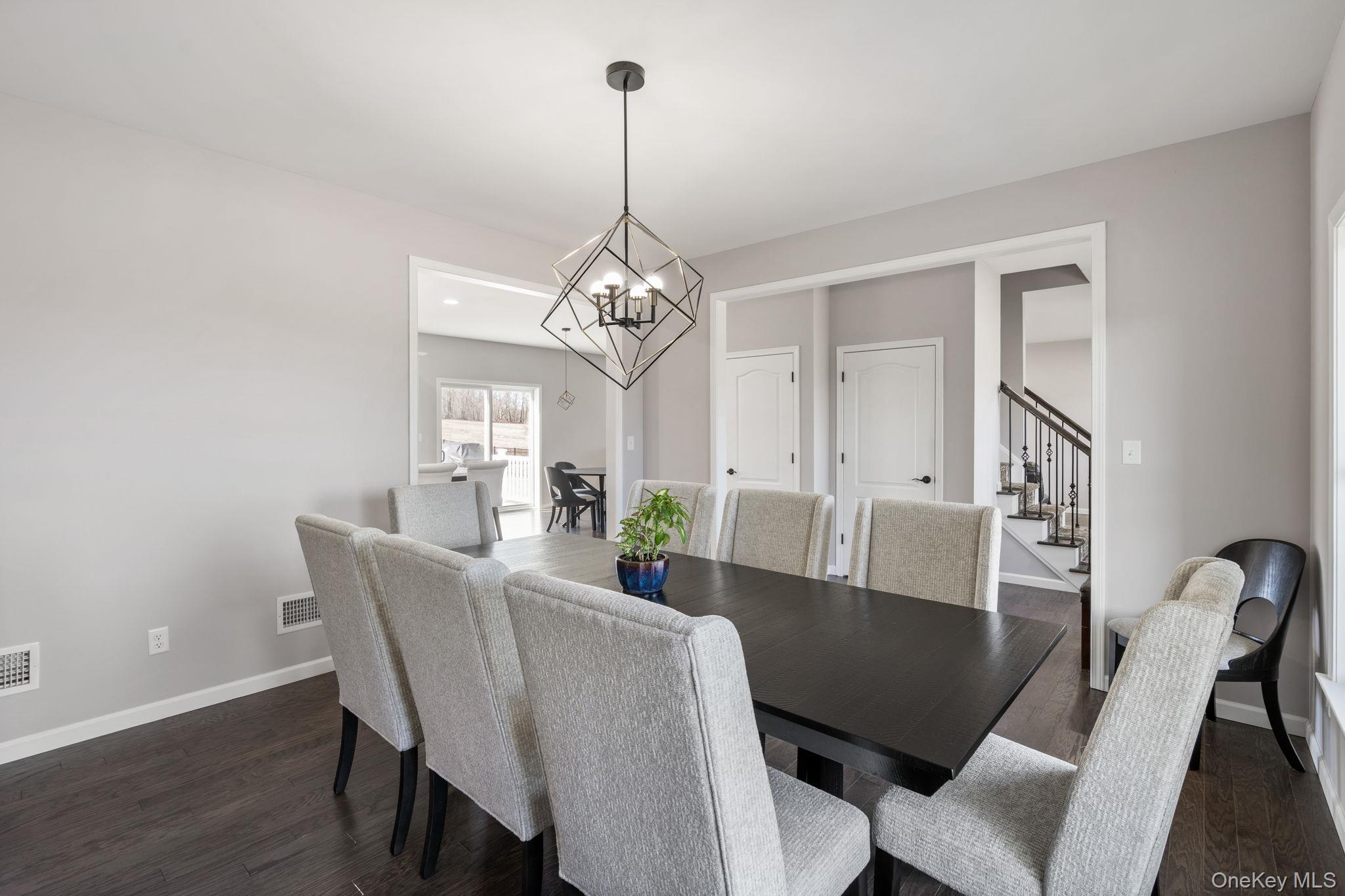 10 Harrier Ridge Drive Wallkill, NY 12589 - Photo 11 of 46 Dining space with stairway, dark wood-style floors, and a chandelier