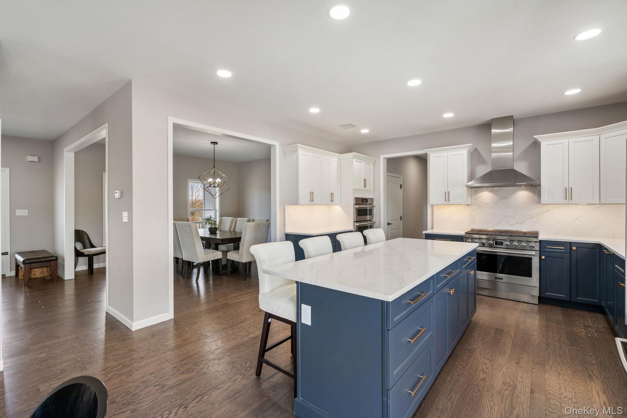 10 Harrier Ridge Drive Wallkill, NY 12589 - Photo 2 of 46 Kitchen with blue cabinets, a breakfast bar, stainless steel appliances, white cabinets, and tasteful backsplash