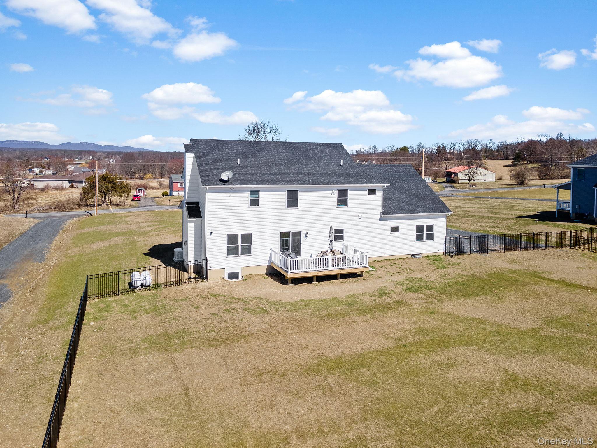 10 Harrier Ridge Drive Wallkill, NY 12589 - Photo 44 of 46 Back of property featuring a fenced backyard, a deck, a shingled roof, and a gate
