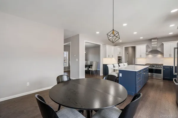 a kitchen with a dining table chairs and wooden floor