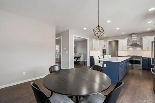 a kitchen with a dining table chairs and wooden floor