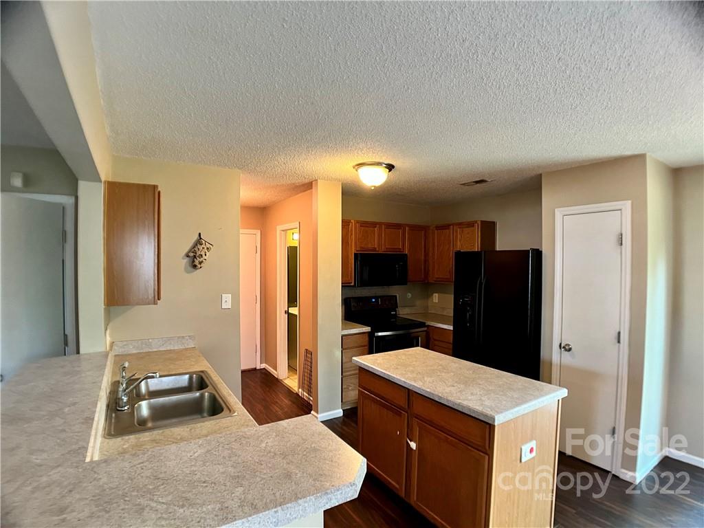 2005 Pimpernel Road Charlotte, NC 28213 - Photo 10 of 24 a kitchen with a refrigerator a stove top oven a sink and dishwasher