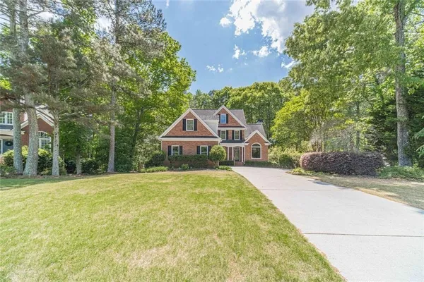 a front view of a house with yard and green space