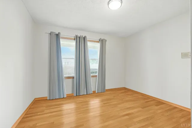 a view of a room with wooden floor and window