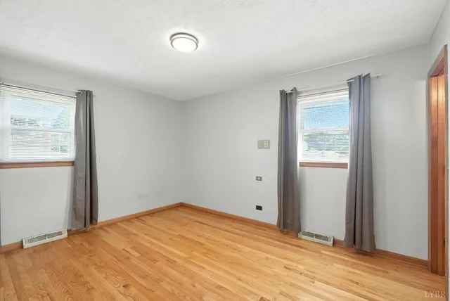 a view of a room with wooden floor and a bathroom