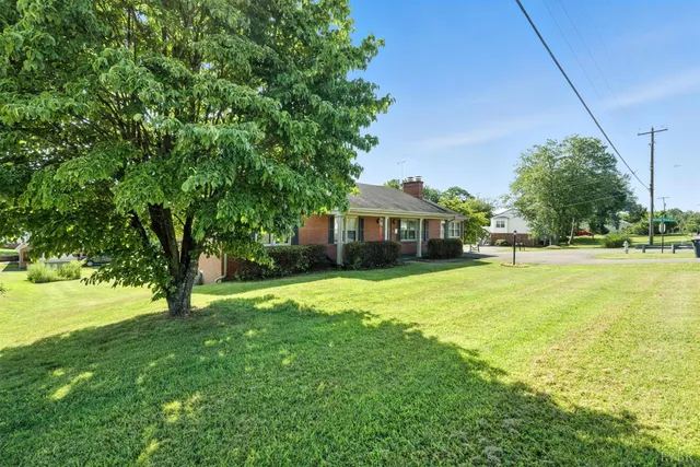 an aerial view of a house with a garden and lake view
