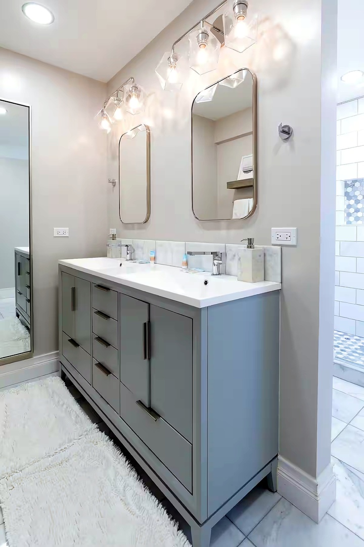 1427 North Mohawk Street Chicago, IL 60610 - Photo 36 of 54 a spacious bathroom with a double vanity sink and mirror