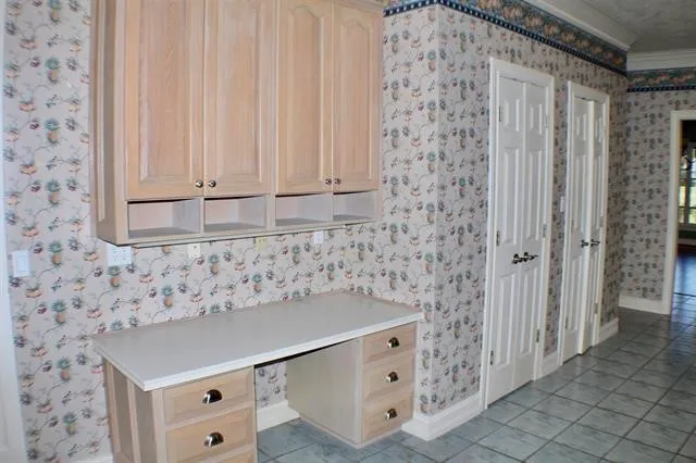 a room with a black white checkered floor and white cabinets