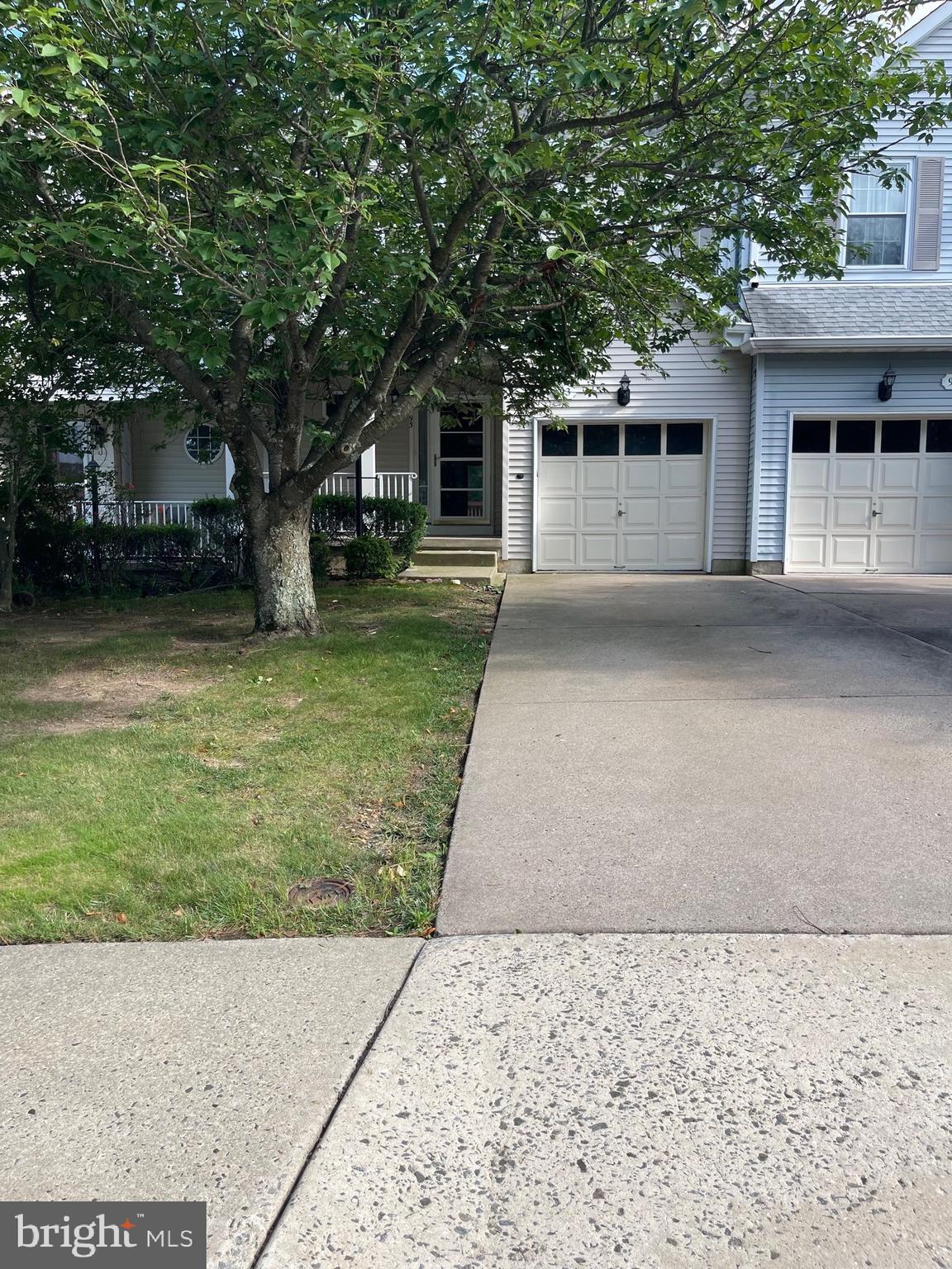 a front view of a house with a garden and trees