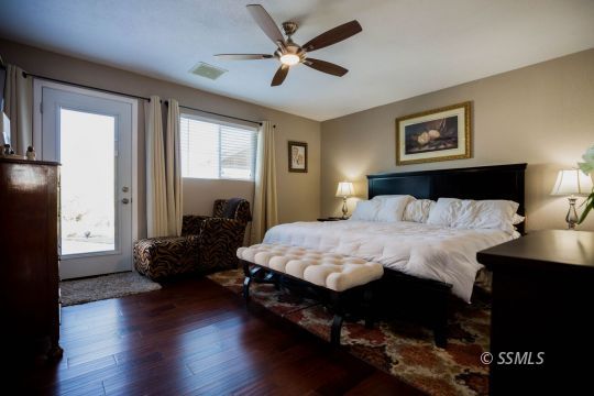 500 Scott Street Ridgecrest, CA 93555 - Photo 25 of 37 a bedroom with a bed and wooden floor