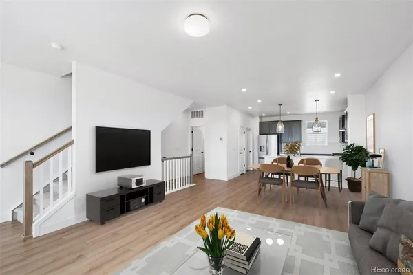a living room with furniture a flat screen tv and kitchen view